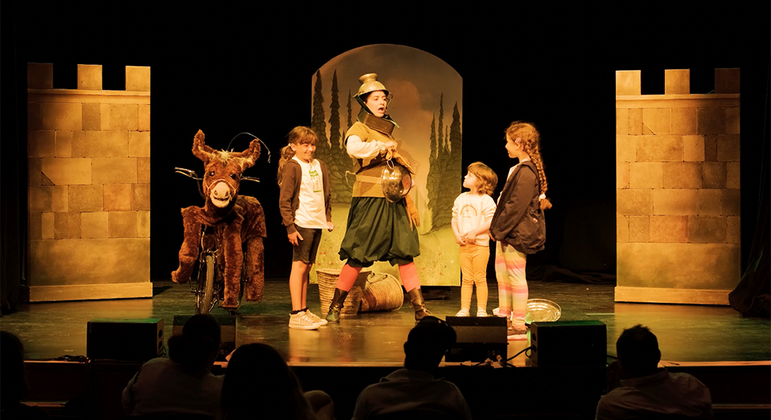 Natasha performing on stage with a few children volunteers in Will Tell. Photo Euan Jennings